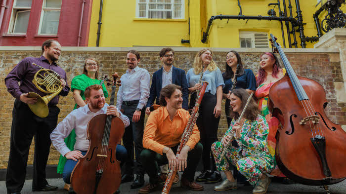 The ten musician members of the Collective either standing or crouching in two rows